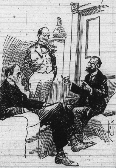 A bearded man in a chair speaks to two men, one seated facing him, the other standing and facing him.